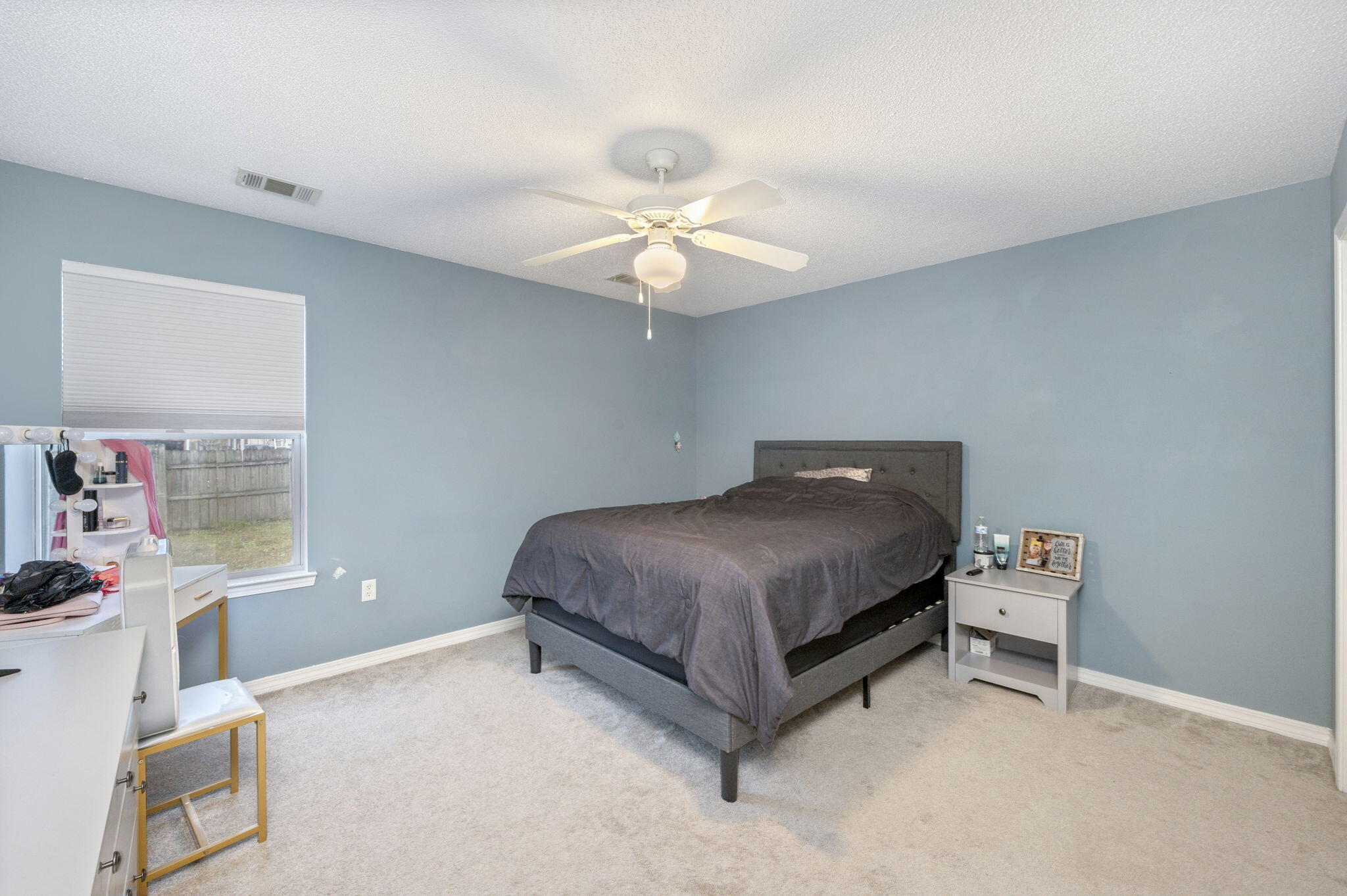 2139 Tom Street Navarre, FL 32566 - Photo 16 of 32 a bedroom with a bed and a chandelier