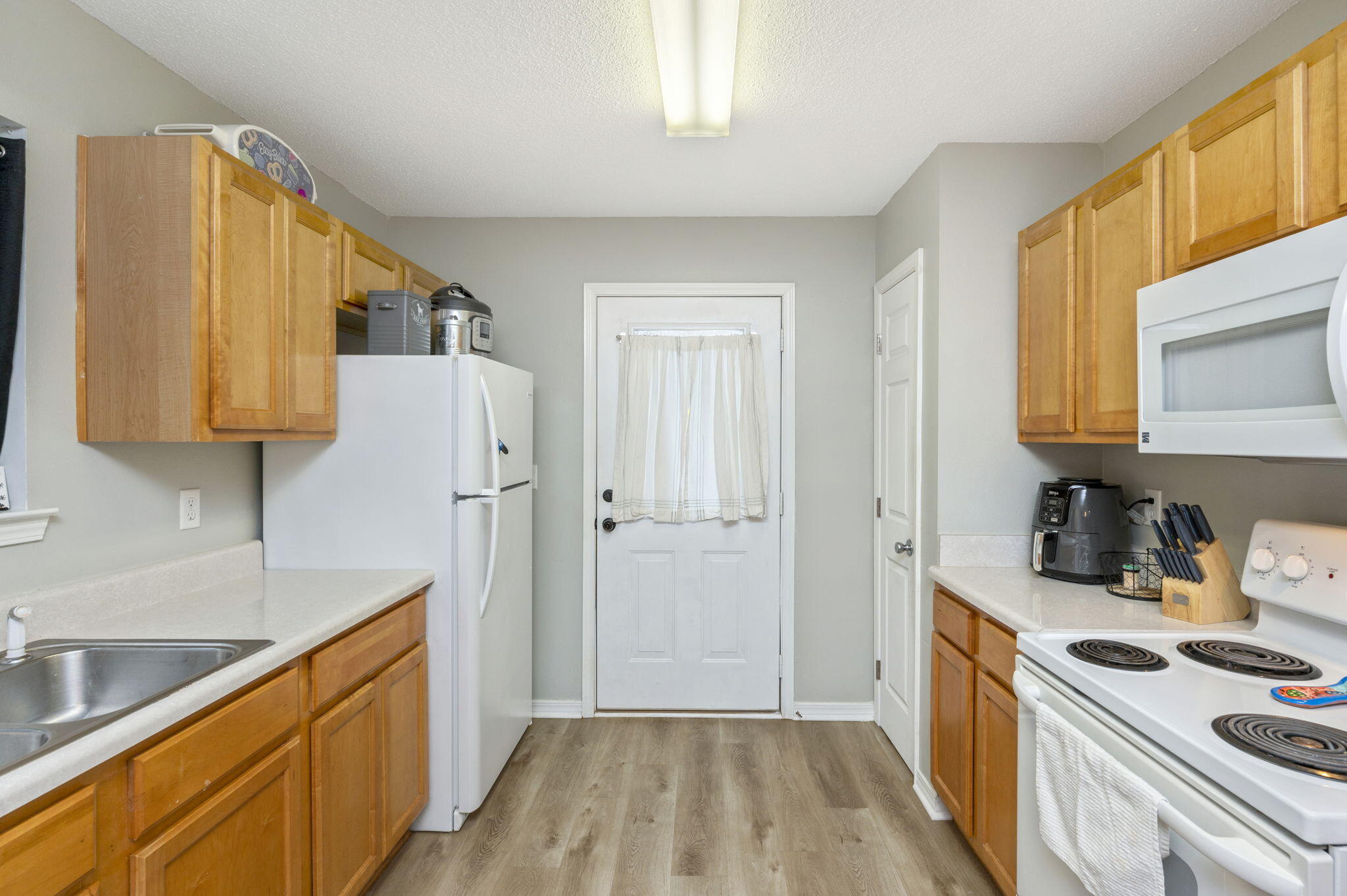 2139 Tom Street Navarre, FL 32566 - Photo 17 of 32 a kitchen with stainless steel appliances a stove a sink and a refrigerator