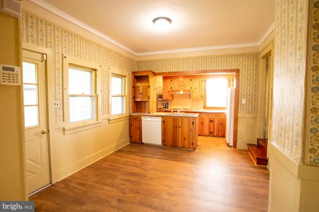 a view of a large kitchen with wooden floor and a window