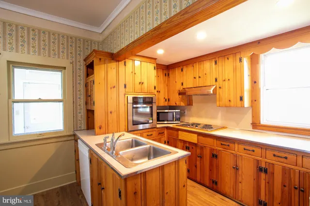 a kitchen with stainless steel appliances granite countertop a sink and a refrigerator
