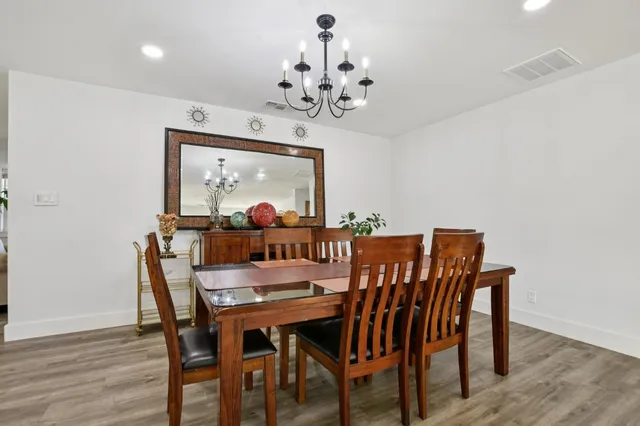 a view of a dining room with furniture a chandelier and wooden floor