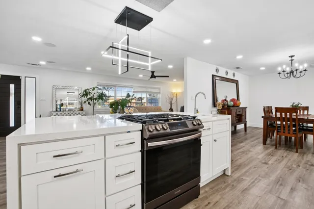 a kitchen with a stove and chairs