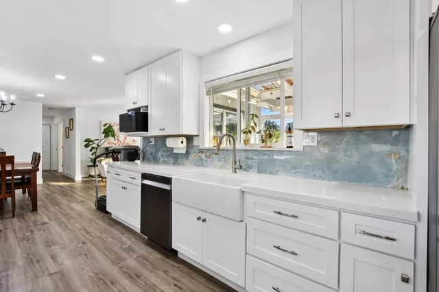 a kitchen with white cabinets sink and stainless steel appliances