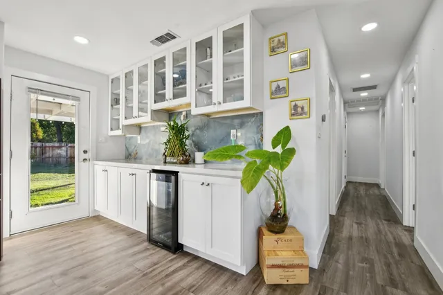 a vase of flowers sitting on a table with window