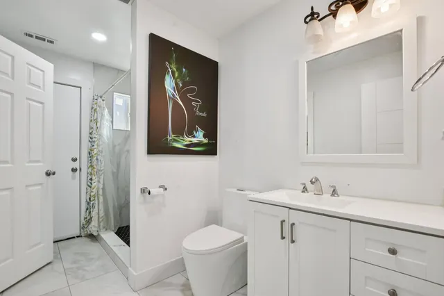 a bathroom with a granite countertop sink toilet and shower