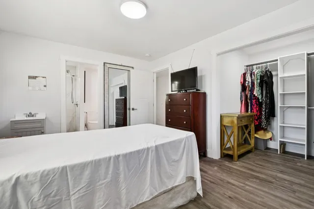 a bedroom with a bed and a flat screen television