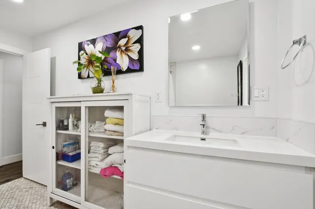 a bathroom with a sink mirror and vanity