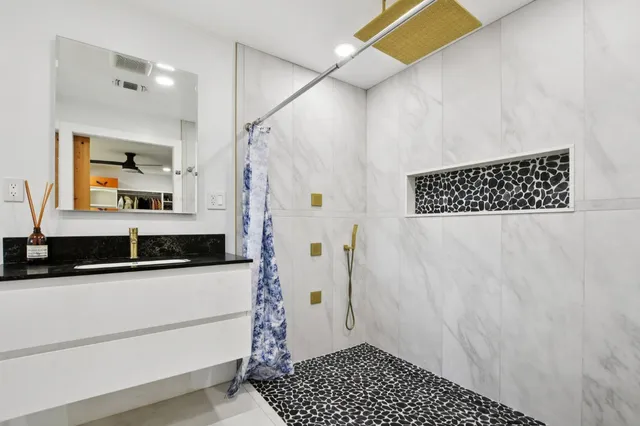 a bathroom with a sink a mirror and a shower