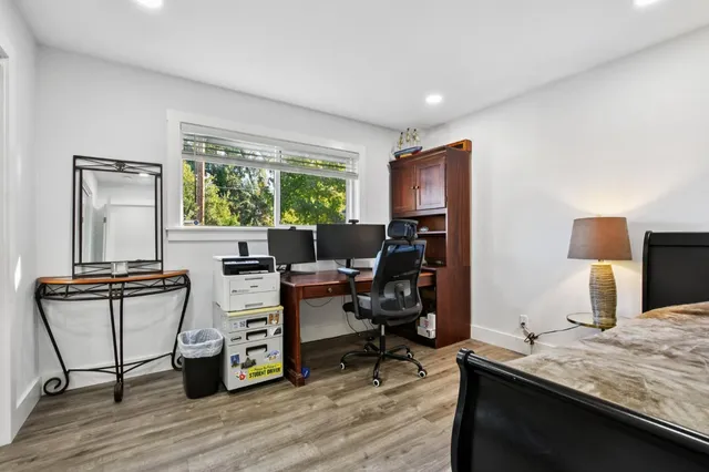 a view of a workspace with furniture and a window