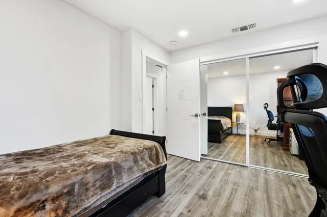 a spacious bedroom with a bed and a mirror