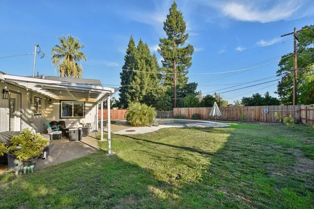 a view of a house with backyard and sitting area