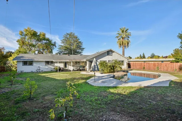 a view of a house with a backyard and a garden