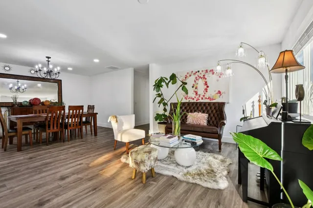 a living room with furniture a table and wooden floor