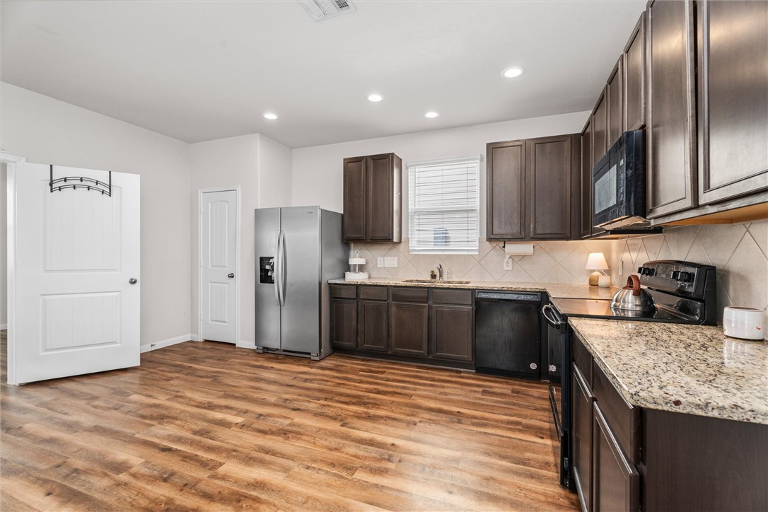 980 Rice Drive Bryan, TX 77803 - Photo 11 of 31 a kitchen with stainless steel appliances granite countertop a refrigerator sink and cabinets