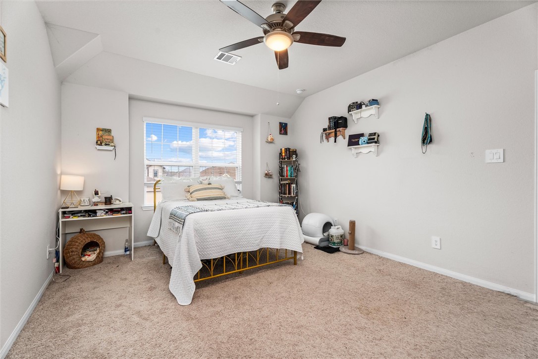 980 Rice Drive Bryan, TX 77803 - Photo 18 of 31 a bedroom with a bed and a chandelier