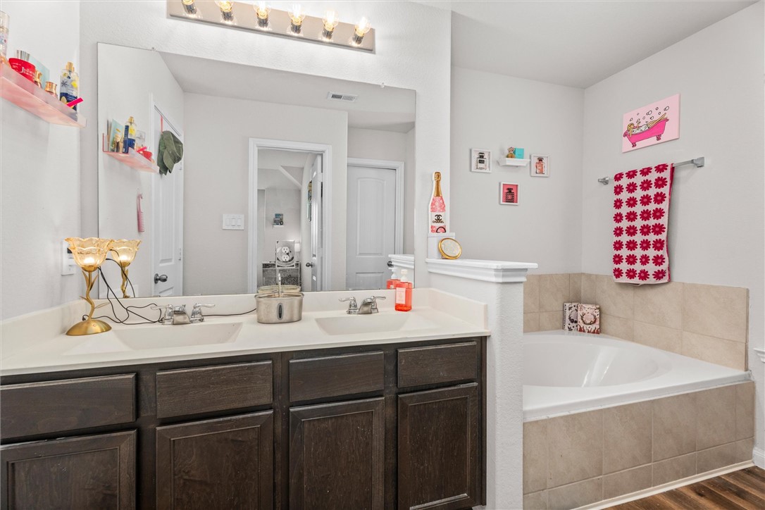 980 Rice Drive Bryan, TX 77803 - Photo 19 of 31 a bathroom with a sink vanity and a mirror