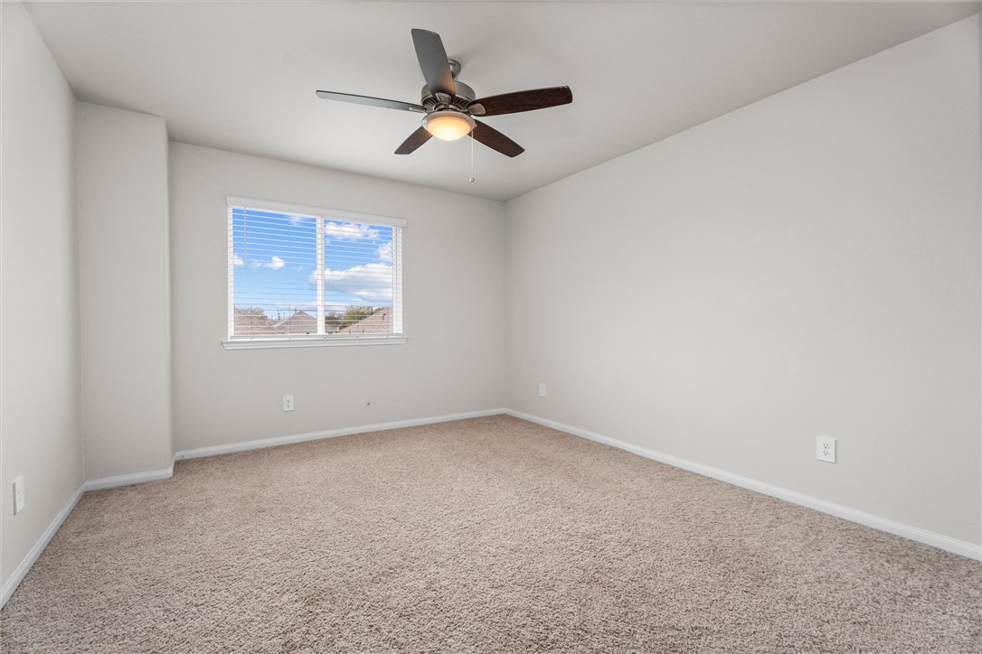 980 Rice Drive Bryan, TX 77803 - Photo 22 of 31 an empty room with a ceiling fan and windows