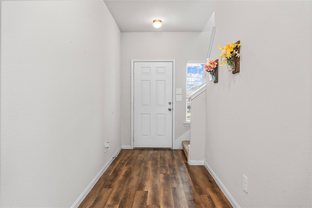 980 Rice Drive Bryan, TX 77803 - Photo 3 of 31 a view of a hallway with wooden floor and a bathroom
