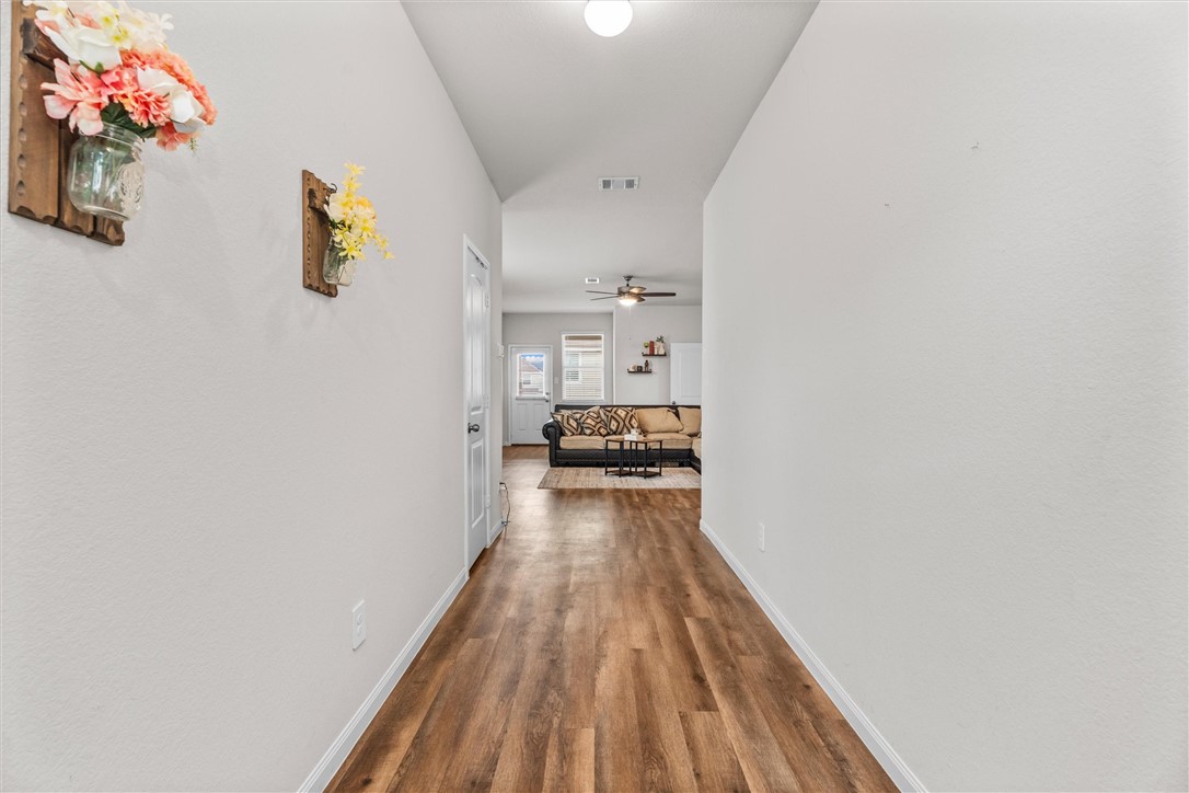 980 Rice Drive Bryan, TX 77803 - Photo 4 of 31 a view of a hallway with wooden floor and a bathroom