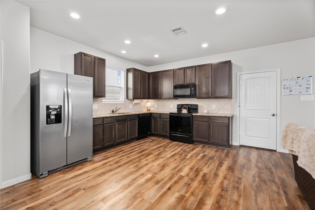 980 Rice Drive Bryan, TX 77803 - Photo 9 of 31 a kitchen with stainless steel appliances granite countertop a refrigerator sink and wooden cabinets