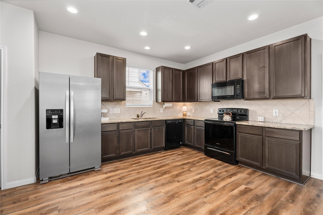 980 Rice Drive Bryan, TX 77803 - Photo 10 of 31 a kitchen with stainless steel appliances granite countertop a refrigerator sink and cabinets