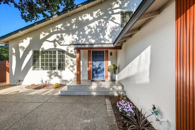 a view of a dining room with furniture and potted plant