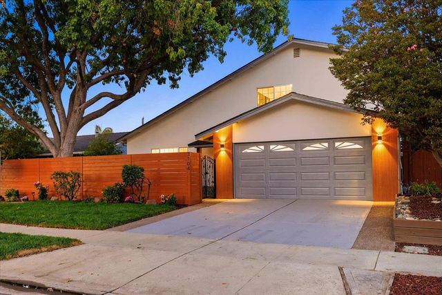 a view of a house with a backyard and a tree