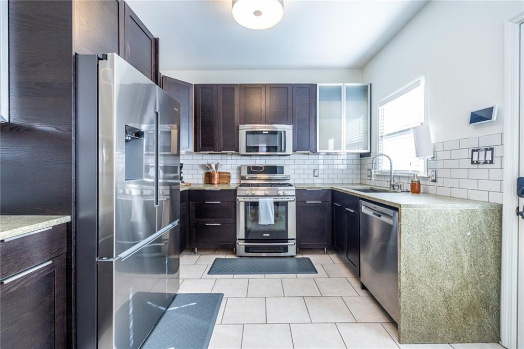 69 Randolph Street Northeast, Unit A Atlanta, GA 30312 - Photo 19 of 50 a kitchen with stainless steel appliances granite countertop a refrigerator and a stove top oven