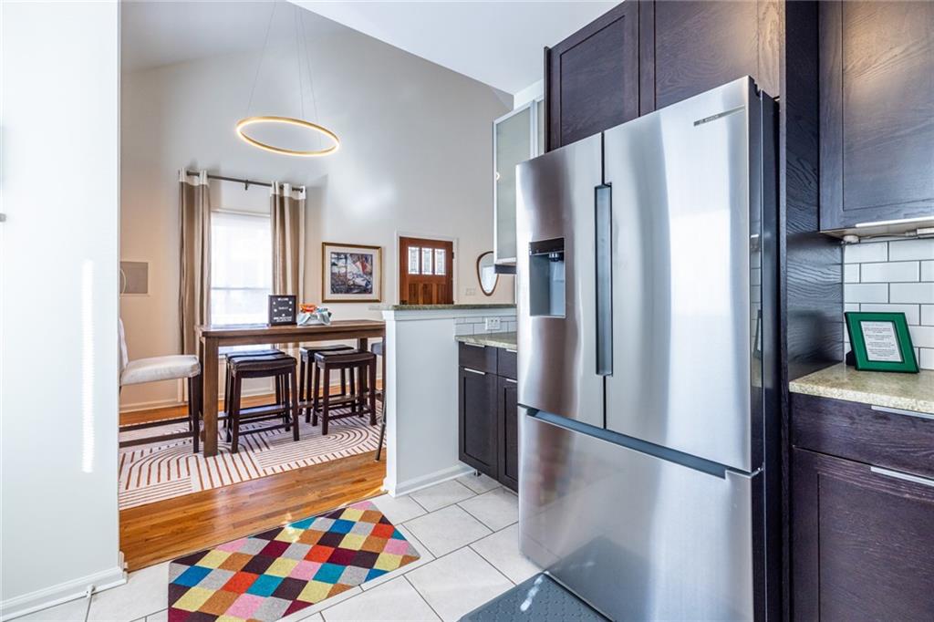 69 Randolph Street Northeast, Unit A Atlanta, GA 30312 - Photo 22 of 50 a kitchen with stainless steel appliances a refrigerator and a dining table