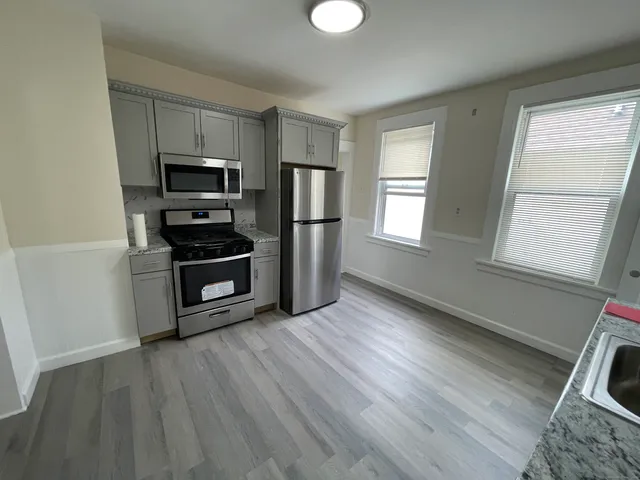 a kitchen with wooden floors and stainless steel appliances
