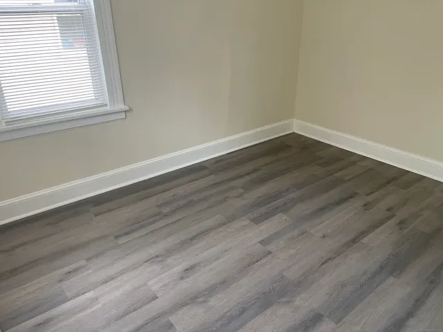 a view of a small space with wooden floor and a window