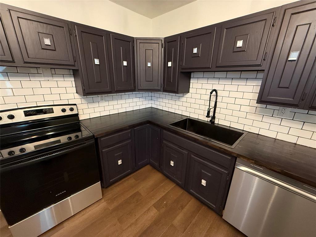 610 5th Street Hawley, TX 79525 - Photo 3 of 19 a kitchen with wooden cabinets and a stove top oven