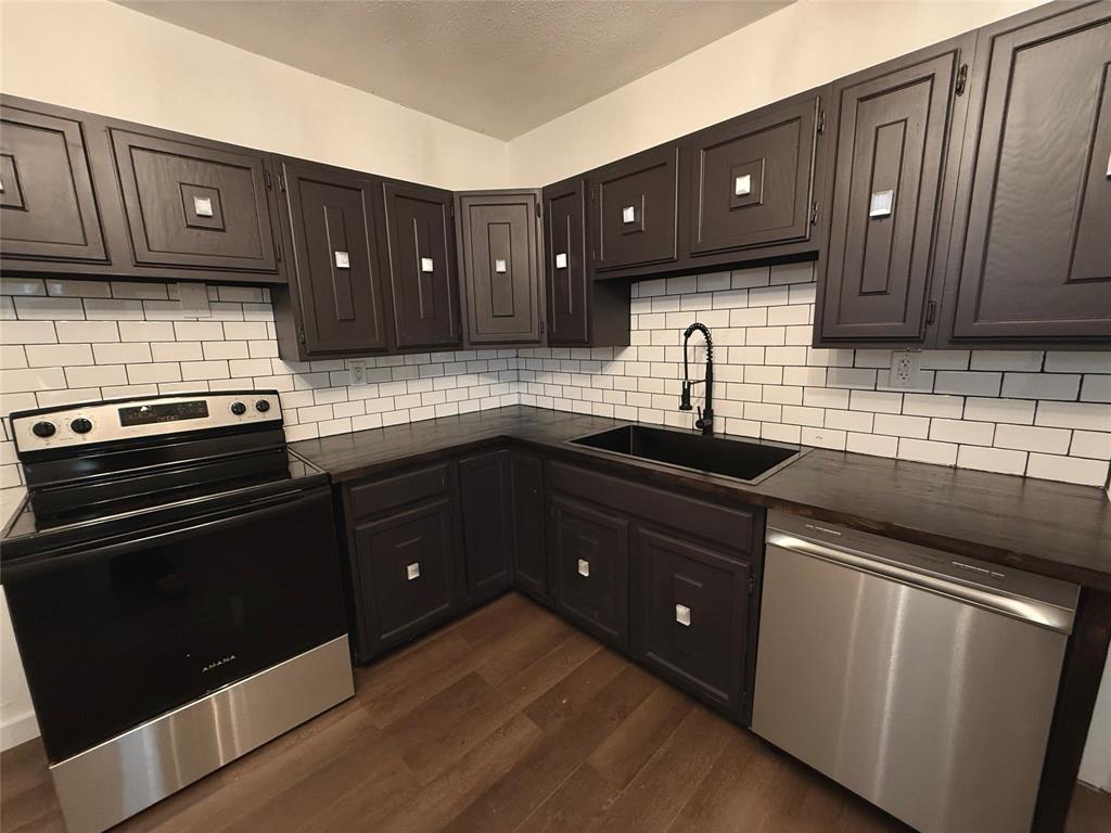 610 5th Street Hawley, TX 79525 - Photo 6 of 19 a kitchen with granite countertop a refrigerator and a sink