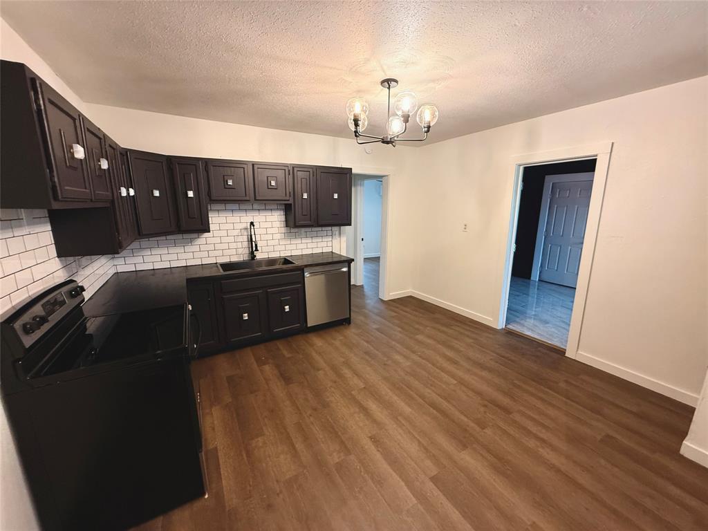 610 5th Street Hawley, TX 79525 - Photo 8 of 19 a kitchen with granite countertop a sink cabinets and wooden floor