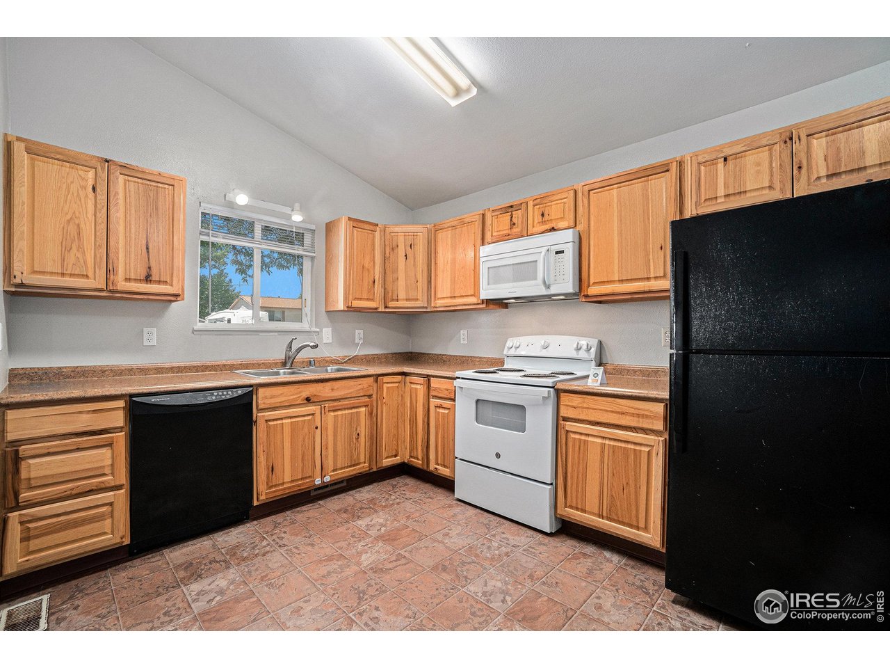 1634 San Juan Circle Evans, CO 80620 - Photo 4 of 20 a kitchen with granite countertop a refrigerator stove top oven a sink and dishwasher