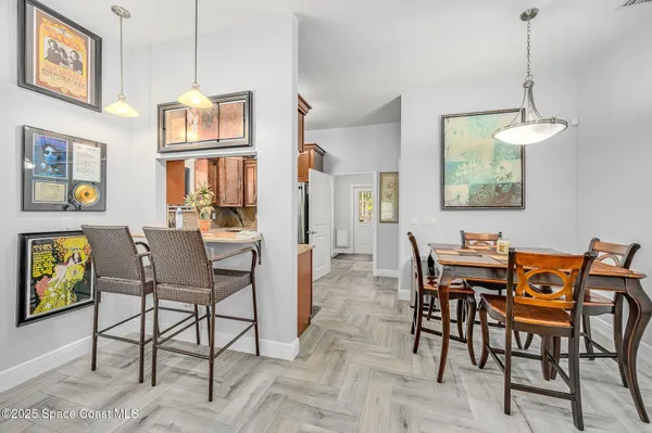a view of a dining room with furniture a rug and wooden floor