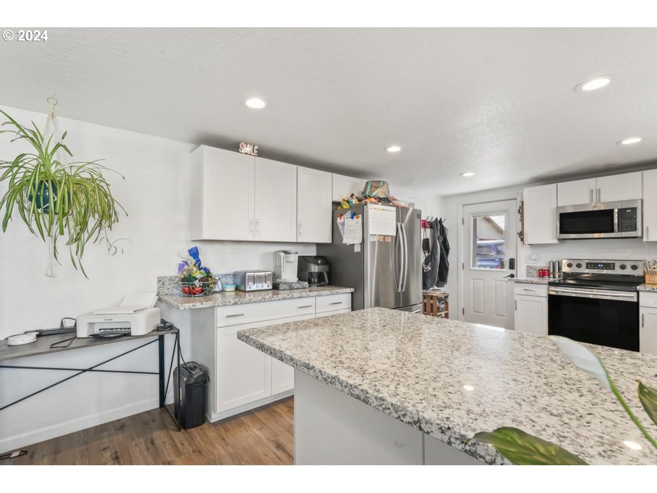 1147 33rd Street Springfield, OR 97478 - Photo 9 of 44 a kitchen with stainless steel appliances kitchen island granite countertop a stove a sink and a refrigerator