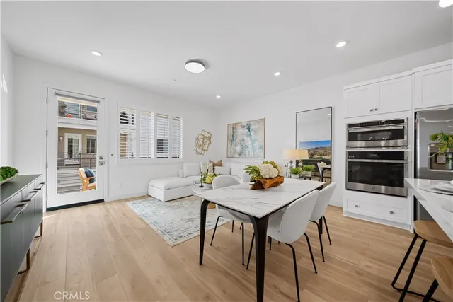 a living room with stainless steel appliances furniture a rug kitchen view and a kitchen island