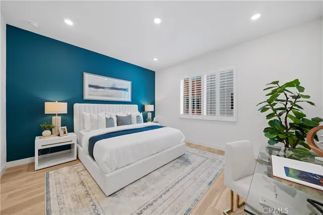 a bedroom with a large bed and a potted plant