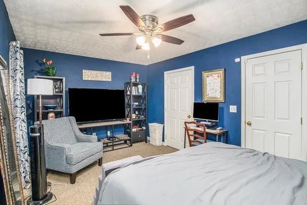 a bedroom with furniture a flat screen tv and a chandelier