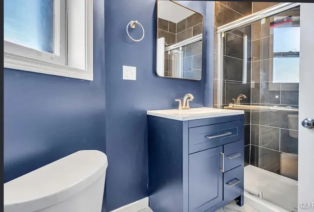 a bathroom with a sink a toilet and shower