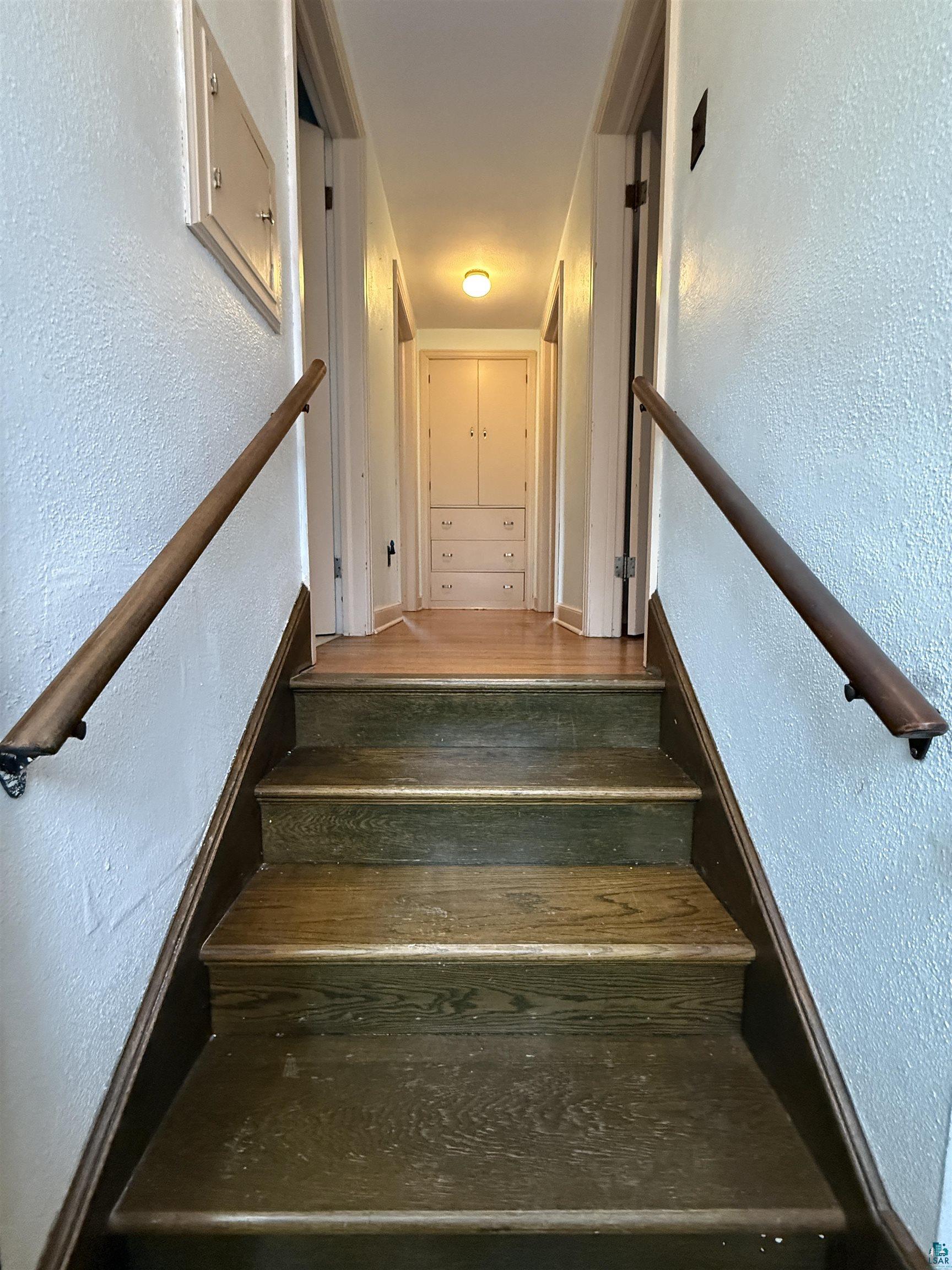 3001 3rd Avenue West Hibbing, MN 55746 - Photo 20 of 38 Stairway featuring a textured wall and wood finished floors