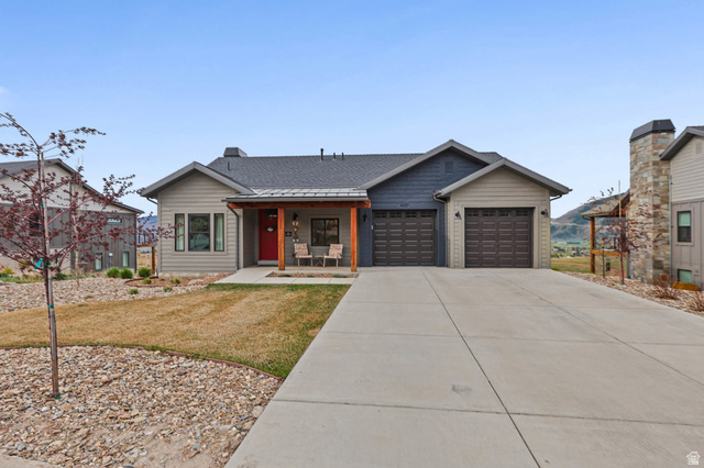 4527 North Seven Bridges Road Eden, UT 84310 - Photo 57 of 65 View of front of house with covered porch, roof with shingles, a front yard, concrete driveway, and a garage