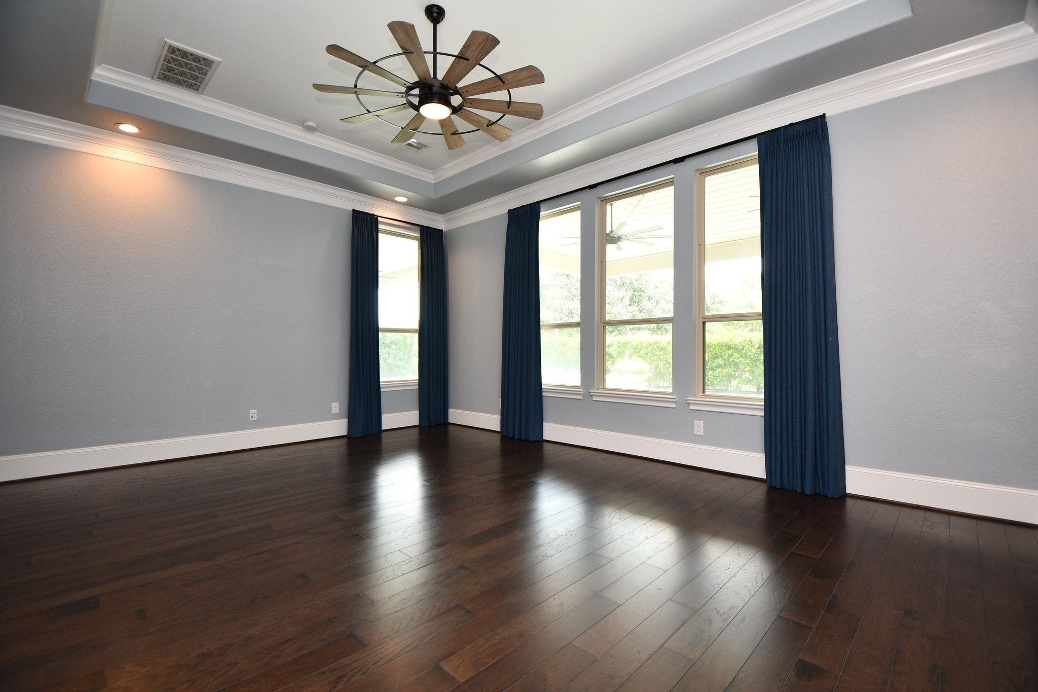 24914 Bay Mist Ridge Lane Katy, TX 77494 - Photo 31 of 50 Another view of the primary bedroom with lots of windows and a fantastic ceiling fan with light kit.