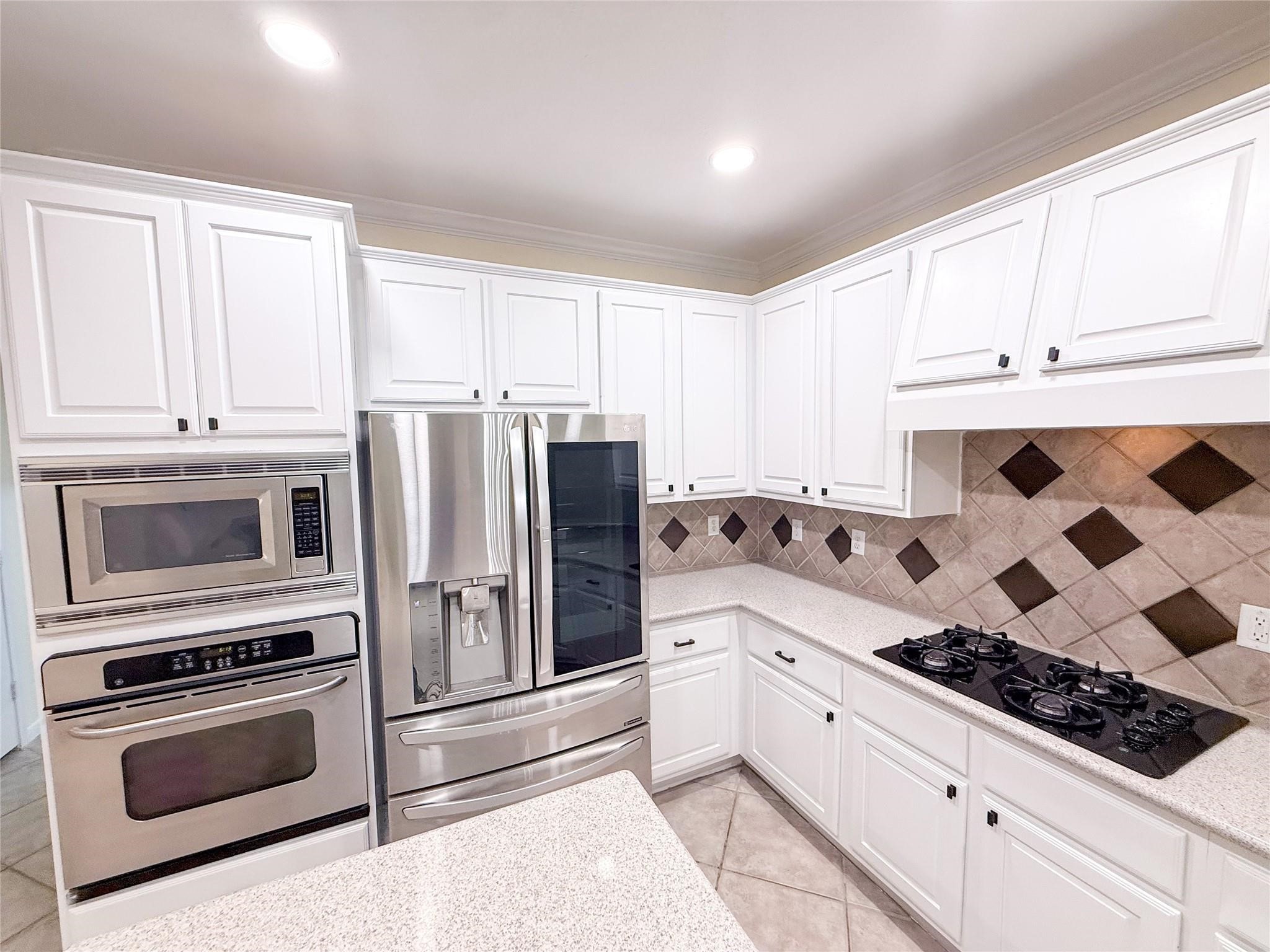 79 West Shale Creek Circle Spring, TX 77382 - Photo 11 of 29 a kitchen with stainless steel appliances a stove a microwave and a refrigerator