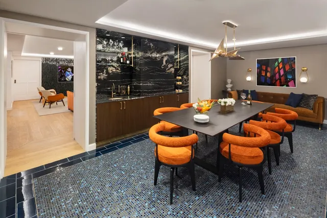 a living room with furniture and a flat screen tv with kitchen view