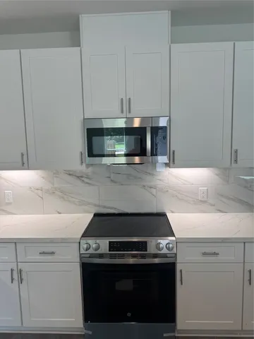 a stove top oven sitting inside of a kitchen