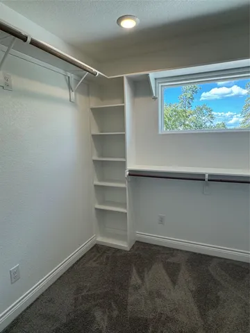 a view of walk in closet with empty racks
