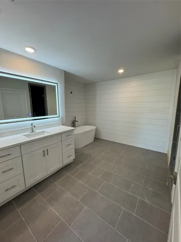 a spacious bathroom with a double vanity sink and mirror