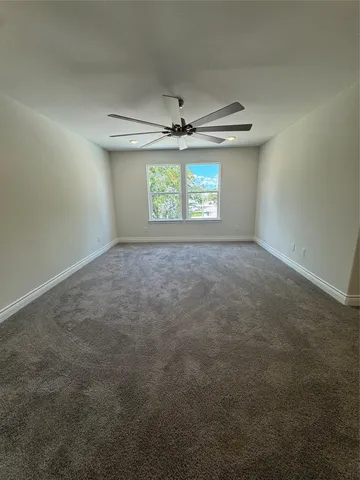 an empty room with windows and ceiling fan